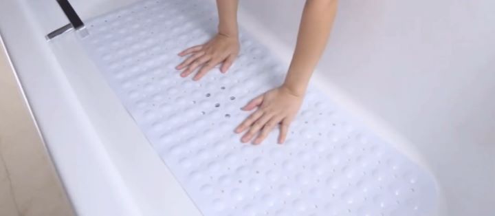 Placing the white non slip mat on the bath tub