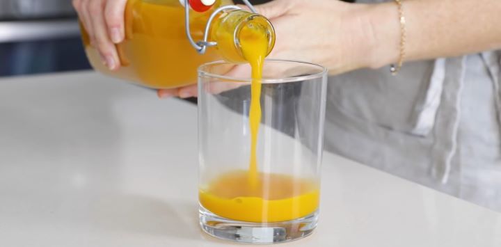 Pouring an orange juice into a glass