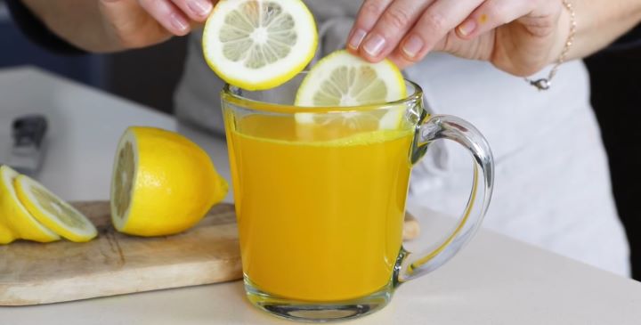 Putting a sliced lemon into a drink